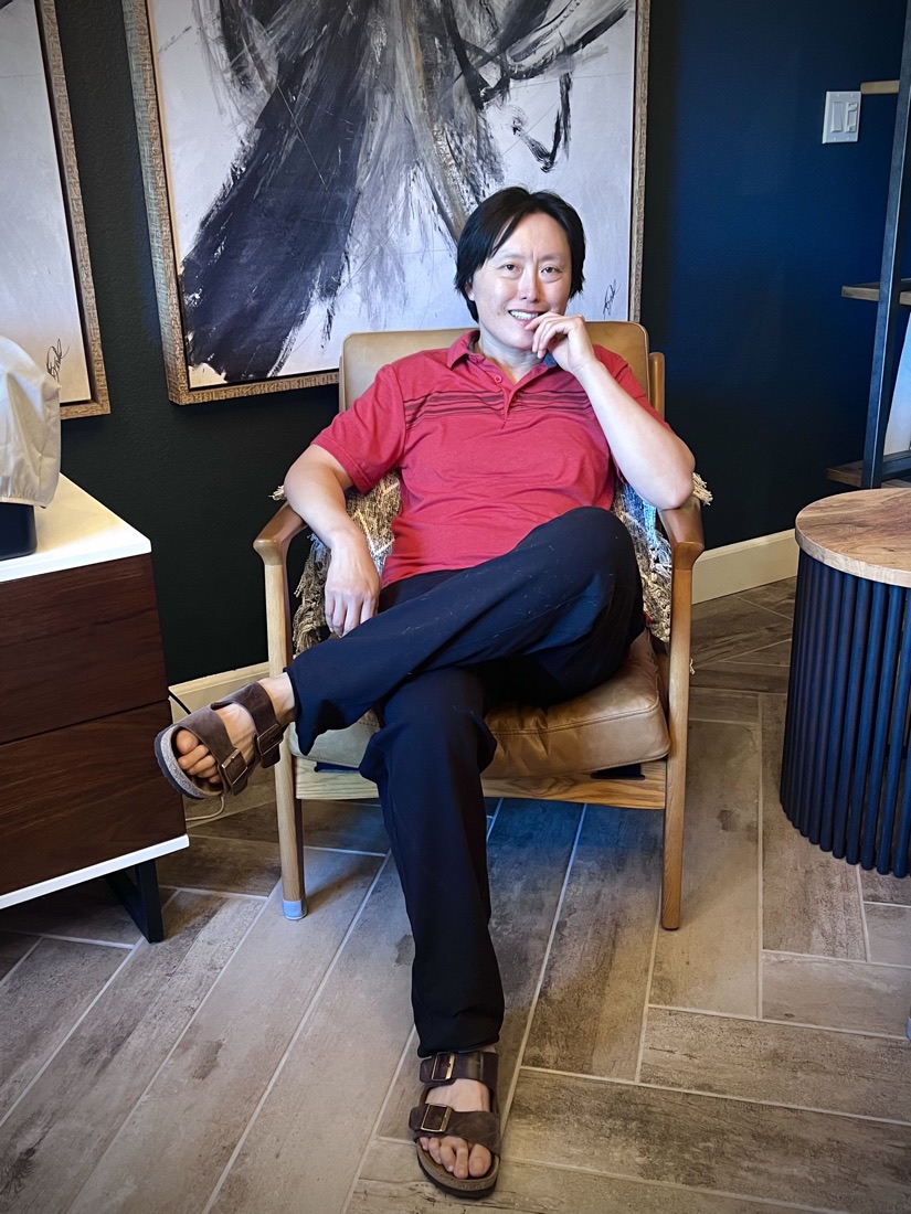 Hui-Meng Tsai sitting in an armchair in a softly lit office